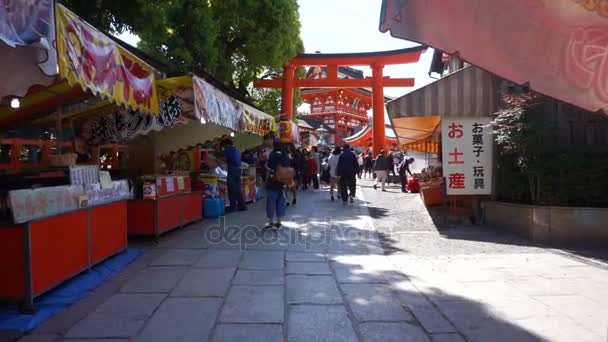 Turis berjalan-jalan di jalan perbelanjaan dekat arsitektur Kuil Fushimi Inari — Stok Video
