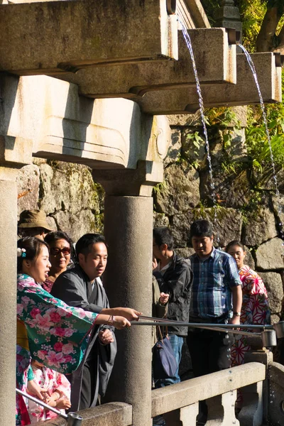 Turist samla vatten från vattenfallet Otowa-nr-taki — Stockfoto