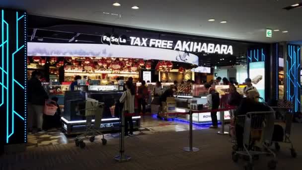 Utazó szívesen vásárol a Fasola "Adómentes Akihabara" boltban a Narita Nemzetközi Repülőtéren — Stock videók