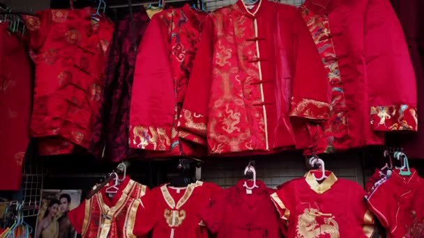 Tradiční čínské šaty pověšené na stojanu na prodej — Stock video