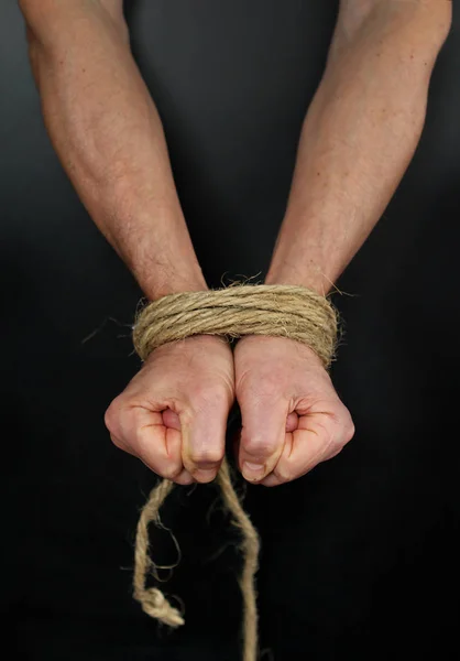 Male hands tied up with rope