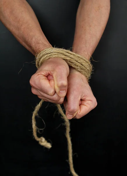 Male hands tied up with rope