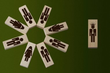 symbol of 8 men and women on wooden blocks, on the right businessman in the crown, head concept, hierarchy in a diverse group, copy space clipart