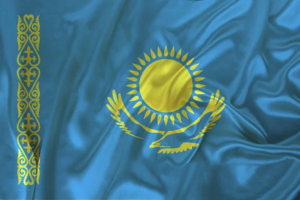 Bella foto di una bandiera nazionale colorata dello stato moderno del Kazakistan su un tessuto strutturato, concetto di turismo, emigrazione, economia e politica, primo piano — Foto Stock
