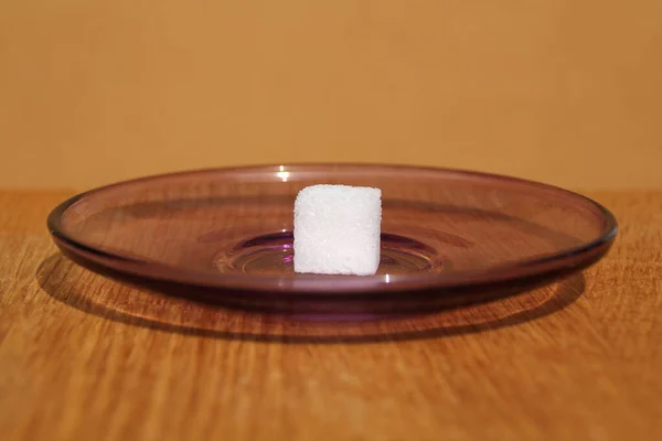 Un cube de sucre blanc sur une assiette, concept de consommation excessive de sucre, diabétique, gros plan, espace de copie — Photo