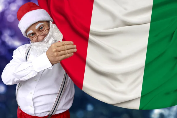 Papai Noel com barba segura uma bela bandeira nacional colorida do estado da Itália em tecido, conceito de turismo, Ano Novo e Natal, perspectivas econômicas e políticas — Fotografia de Stock