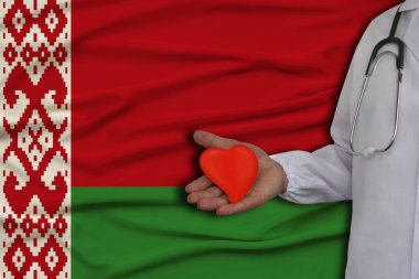 Belarus bayrağının arka planında steteskoplu bir kalp modeli olan bir doktorun fotoğrafı, sağlık, kardiyoloji, sağlık sigortası kavramı