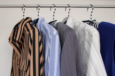 farklı renkte kadın kıyafetleri, çizgili, askılık, moda ve alışveriş konsepti.
