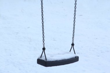 Bir çocuğun kışın yalnız salıncağında doğal beyaz karın ışıl ışıl dokusu