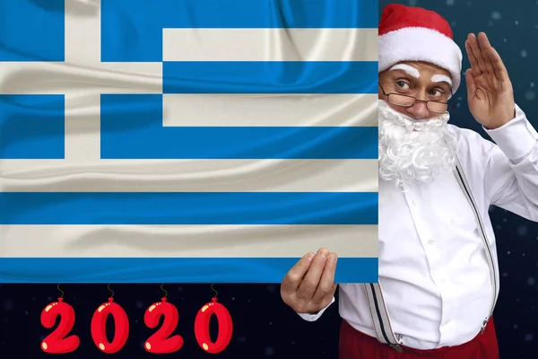 Santa Claus med skägg innehar en vacker foto färgad nationell flagga i den moderna staten Grekland med en festlig dag 2020, begreppet turism, det nya året, ekonomiska och politiska framtidsutsikter — Stockfoto