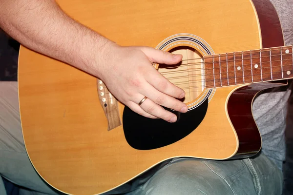 Férfi játszik egy hathúros fa gitár, zenei koncepció, közelkép — Stock Fotó