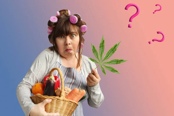Vrouw van middelbare leeftijd, een huisvrouw in krulspelden houdt een mand met groenten in de ene hand, en een marihuana blad in de andere, vragen — Stockfoto