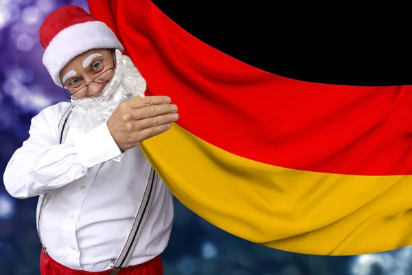 Weihnachtsmann mit Bart hält eine schöne farbige Nationalflagge des Bundeslandes Deutschland auf Stoff, Tourismuskonzept, Neujahr und Weihnachten, wirtschaftliche und politische Aussichten — Stockfoto