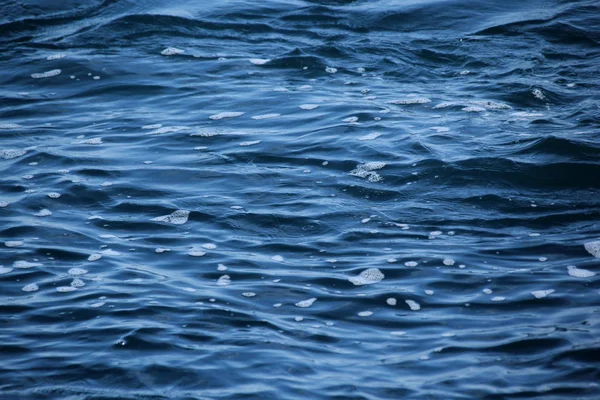 Błękitne morze, fale oceanu, woda z pianki i pęcherzyków, tekstura, koncepcja zasobów naturalnych wody, zbliżenie, przestrzeń kopiowania — Zdjęcie stockowe