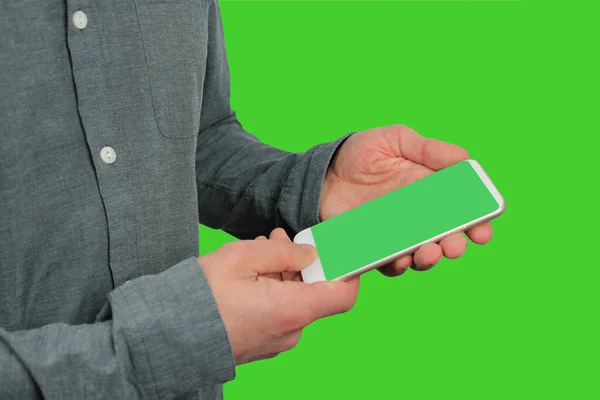 Hombre sostiene un teléfono moderno con pantalla verde en sus manos en un — Foto de Stock