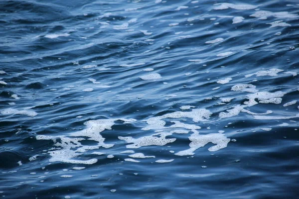 Mare blu, onde oceaniche, acqua con schiuma e bolle, consistenza, concetto di risorse naturali dell'acqua, primo piano, spazio copia — Foto Stock