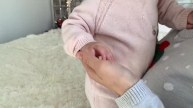 Şefkatli bir anne pembe elbiseli bir bebeğin sapını tutuyor, sağlıklı bir yaşam tarzı, mutlu ebeveynler, çocukluk.