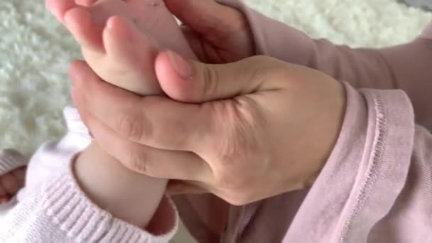 温柔的母亲牵着她的小女儿的腿 做着轻微的足底按摩 健康的生活方式 快乐的父母 — 图库视频影像