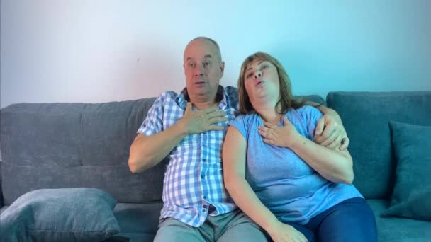 一个男人和一个女人坐在沙发上 在感情上看着电视上的恐怖镜头 — 图库视频影像