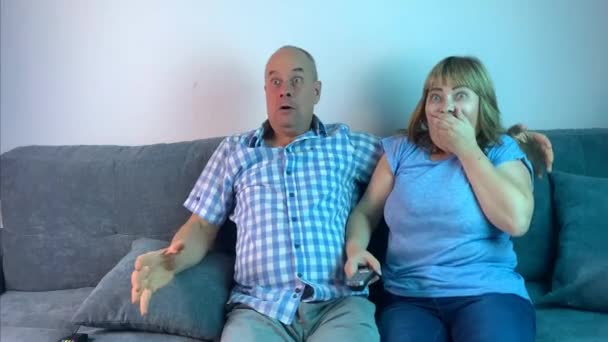Mężczyzna Kobieta Siedzą Obok Siebie Kanapie Emocjonalnie Oglądając Horror Telewizji — Wideo stockowe