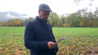 Orta yaşlı bir adam elinde kağıt tutuyor ve duygusal olarak kızgın, olumsuz haber kavramı, yakın plan