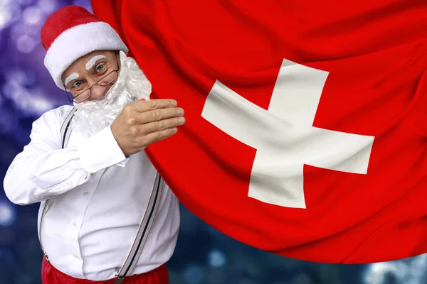Sakallı Noel Baba kumaş, turizm, yeni yıl ve Noel, ekonomik ve politik beklentiler üzerine İsviçre devletinin güzel renkli bir bayrağını elinde tutuyor. — Stok fotoğraf