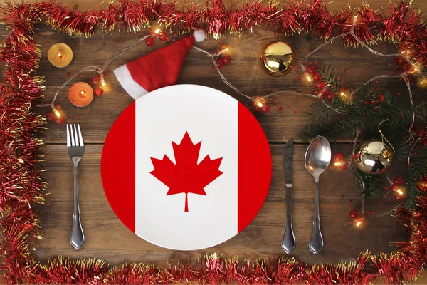 Beautiful christmas composition with plate with national flag of canada, served with cutlery, tinsel, garland, spruce branch, candles, concept traditional christmas food, gastronomic tourism — Stock Photo, Image