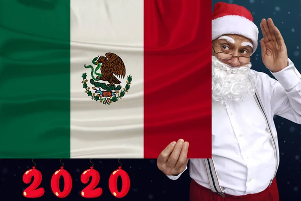 Mikulás szakállas tart egy gyönyörű színes nemzeti zászló Mexikó állam szövet, koncepció a turizmus, újév és karácsony, gazdasági és politikai kilátások — Stock Fotó