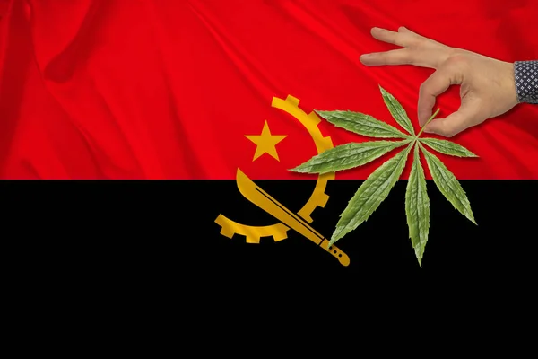 Image of green cannabis leaf on the beautiful Angola national flag, concept of medical cannabis, legalization of drugs, drug addiction crime, close-up — Stock Photo, Image