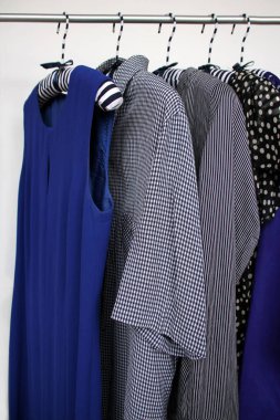 Değişik renkte kadın kıyafetleri, düz ve çizgili, askılarda, moda ve alışveriş konsepti.