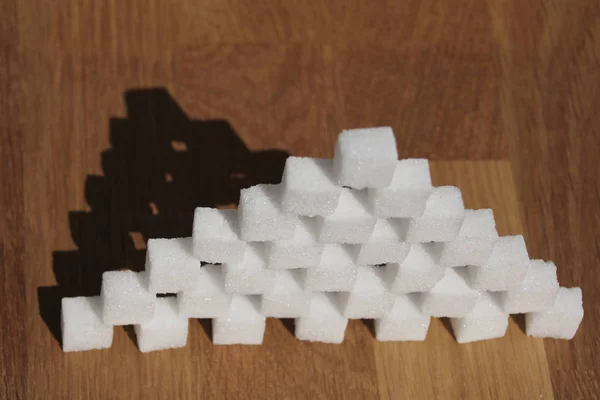 Pyramide de sucre élevée construite en cubes de sucre, concept de consommation excessive de sucre, diabétique, gros plan, espace de copie — Photo
