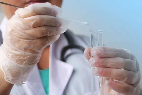 Medizinisches Personal in Handschuhen legt eine Probe für die dna-Analyse auf einen Wattestäbchen in einem Reagenzglas, das Konzept der wissenschaftlichen und medizinischen Untersuchung, Nahaufnahme — Stockfoto