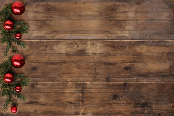 empty mock up in beautiful christmas composition with red christmas balls on old wooden table, christmas tree branch, candles, advent and christmas concept