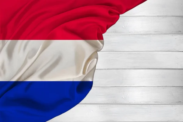 Bandiera nazionale colorata orizzontale dello stato moderno dei Paesi Bassi, bella seta, sfondo in legno bianco, concetto di turismo, economia, politica, emigrazione, giorno dell'indipendenza, spazio copia, modello — Foto Stock