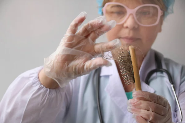 Женщина берет волосы с расческой для исследования генетических исследований в лаборатории, концепция анализа ДНК — стоковое фото