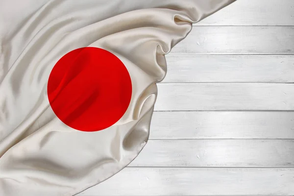 Vízszintes színű nemzeti zászló modern japán állam, gyönyörű selyem, fehér fa háttér, koncepció a turizmus, gazdaság, politika, kivándorlás, függetlenség napja, másolás tér, sablon — Stock Fotó