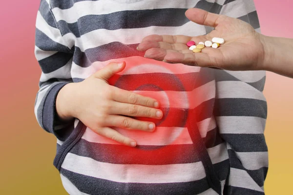 Boy, child in a striped jumper holds his stomach by his hand, re — Stockfoto