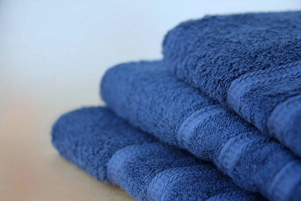 Pile of clean terry cotton blue towels, close-up, on a light background, copy space, concept of cleanliness, bath procedure, spa — Stock Photo, Image