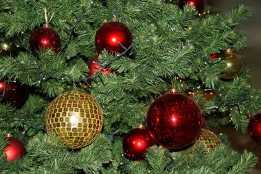 Kırmızı ve sarı topları olan yeşil noel ağacı, ışıklar ve röfleler, şenlikli konsept, tebrik kartı formu, kopyalama alanı