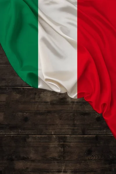 Κατακόρυφο χρώμα εθνική σημαία του σύγχρονου κράτους της Ιταλίας, όμορφο μετάξι, φόντο παλιό ξύλο, έννοια του τουρισμού, την οικονομία, την πολιτική, τη μετανάστευση, την ημέρα της ανεξαρτησίας, αντίγραφο χώρο, πρότυπο — Φωτογραφία Αρχείου
