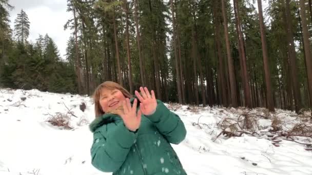 冬天穿着夹克的中年妇女在雪地的森林里鬼鬼祟祟 玩雪球 享受运动 健康的生活方式 — 图库视频影像