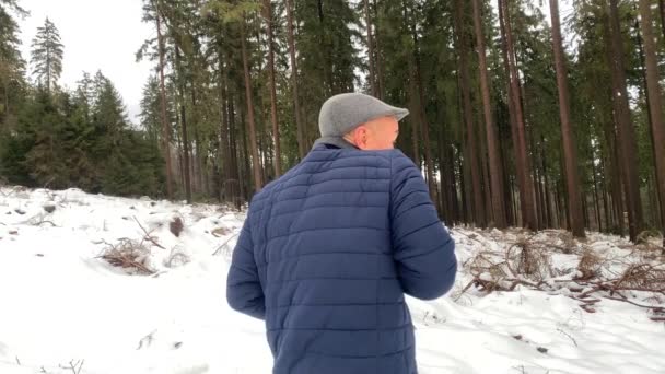 冬天穿着夹克的中年男子 在雪地的森林里 带着大相机的照片 概念爱好 — 图库视频影像
