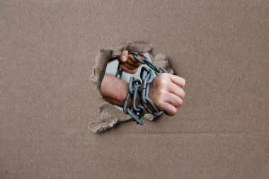 Bir suçlunun tutuklanmasının sembolü olan kalın demir bir zincir takmış erkek elleri