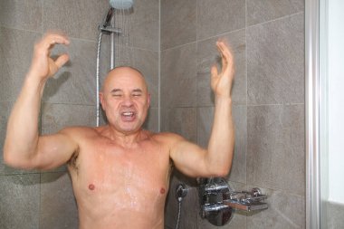 Suyun altında yıkanan ve şarkı söyleyen bir adamın yatay fotoğrafı.