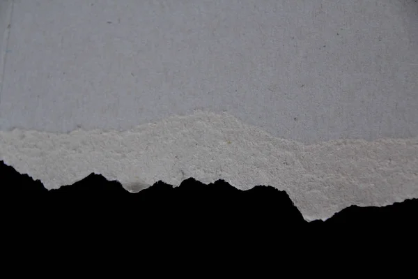 Formulario en blanco con borde áspero rasgado de cartón gris sobre fondo negro, en blanco para el diseñador, primer plano, espacio de copia — Foto de Stock