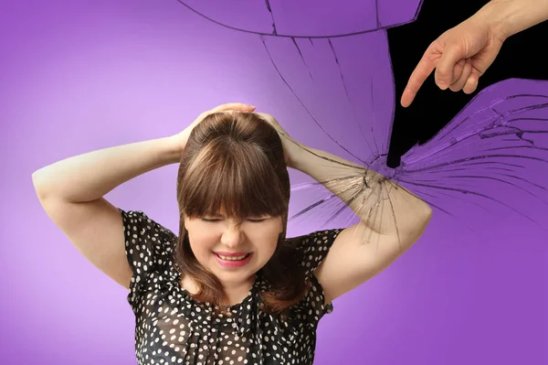 Woman covered her head in despair with her hands, the man, husband, accusingly shows a finger at her, cracks on back of purple background, the concept of gaslighting, psychological abuse, humiliation — Stock Photo, Image