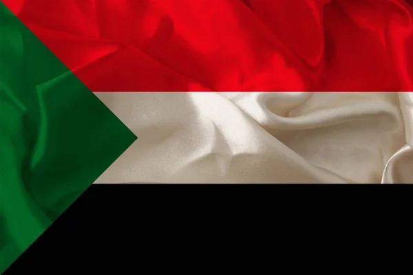 Foto de la hermosa bandera nacional de color del estado moderno de Sudán en un tejido texturizado, concepto de turismo, emigración, economía y política, primer plano — Foto de Stock