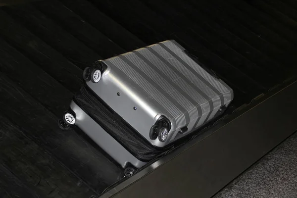 Uma mala está deitada em uma fita de bagagem na sala de chegada dos passageiros do aeroporto, o conceito de reclamação ou perda de bagagem — Fotografia de Stock