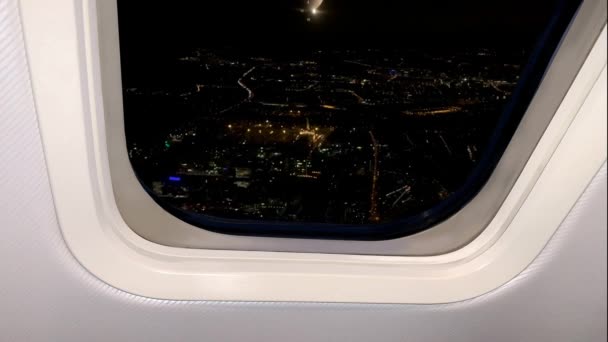 下の暗い都市の神秘的な夜の風景飛行機のポールから明るい光が見える旅行のコンセプト — ストック動画
