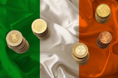 Euro metali, ulusal İrlanda bayrağı, mali kalkınma, devalüasyon, enflasyon ve vergiler kavramının arka planında avro olarak yer alıyor.